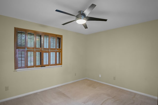 empty room featuring light colored carpet and ceiling fan