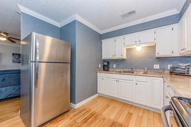 kitchen featuring ceiling fan, appliances with stainless steel finishes, crown molding, white cabinets, and light wood-type flooring