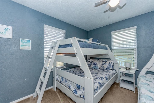 bedroom featuring ceiling fan, light colored carpet, and a textured ceiling