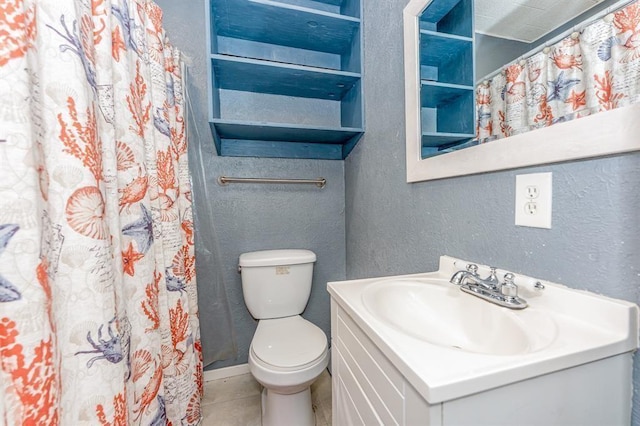 bathroom featuring tile patterned floors, vanity, and toilet