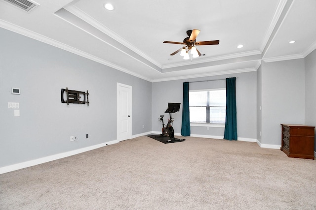 exercise area featuring carpet flooring, a raised ceiling, ceiling fan, and crown molding