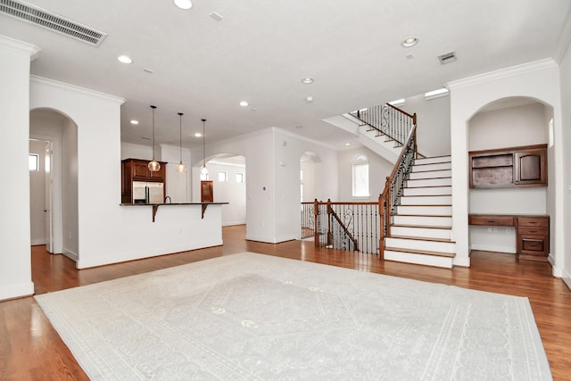 unfurnished living room featuring crown molding and light hardwood / wood-style flooring