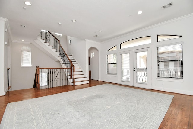 foyer entrance with hardwood / wood-style floors, a healthy amount of sunlight, and ornamental molding