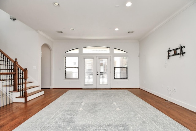 entrance foyer with hardwood / wood-style floors, french doors, and ornamental molding