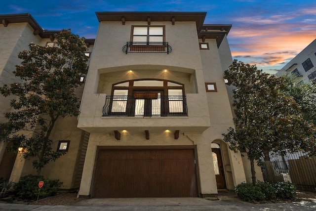 mediterranean / spanish house featuring a garage and a balcony