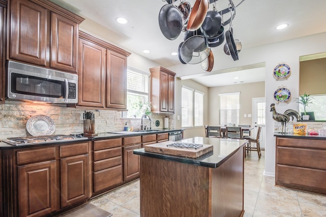 kitchen with a center island, sink, backsplash, and appliances with stainless steel finishes