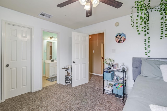 carpeted bedroom with ensuite bathroom, ceiling fan, and sink