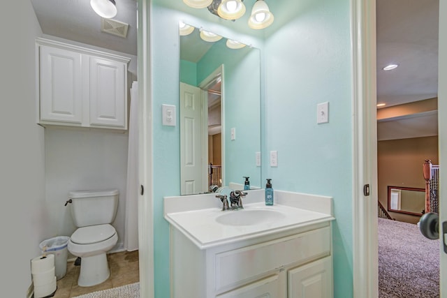 bathroom featuring tile patterned flooring, vanity, and toilet