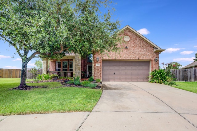 view of front of property featuring covered porch, a garage, and a front yard