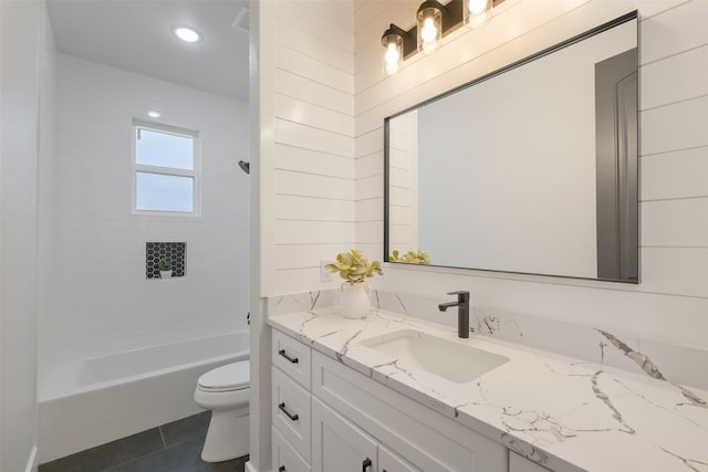 full bathroom featuring tile patterned floors, vanity, tiled shower / bath combo, and toilet