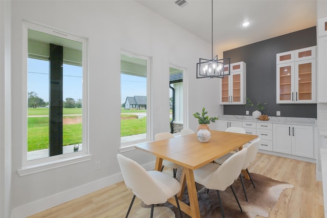 dining area featuring light hardwood / wood-style floors and a notable chandelier