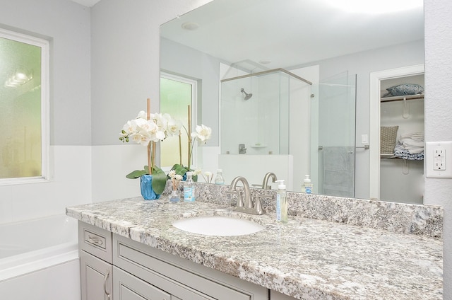 bathroom featuring separate shower and tub and vanity