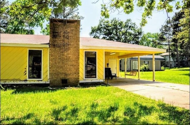 view of front of property featuring a front lawn and a carport