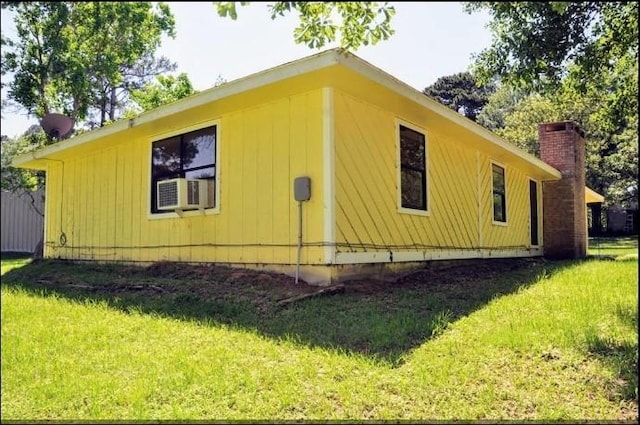 view of side of property featuring a yard and cooling unit