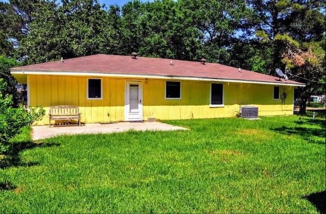 rear view of house featuring a lawn and central air condition unit