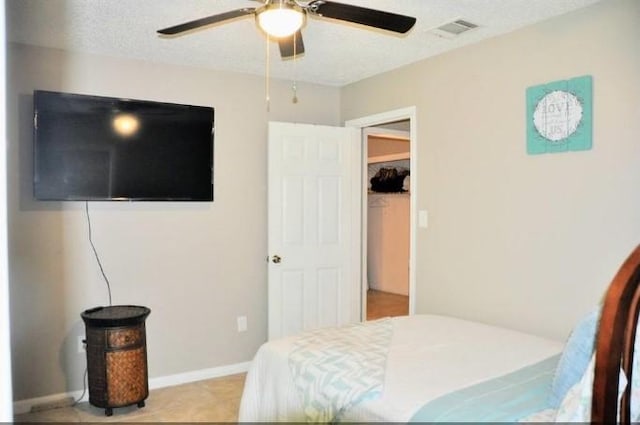 bedroom with ceiling fan and a textured ceiling