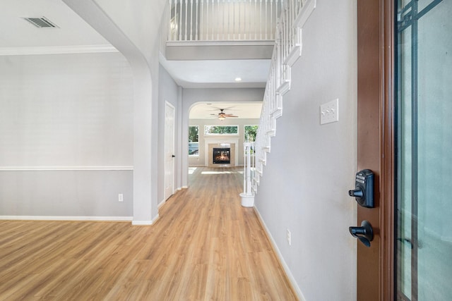 entrance foyer featuring crown molding, ceiling fan, and light wood-type flooring