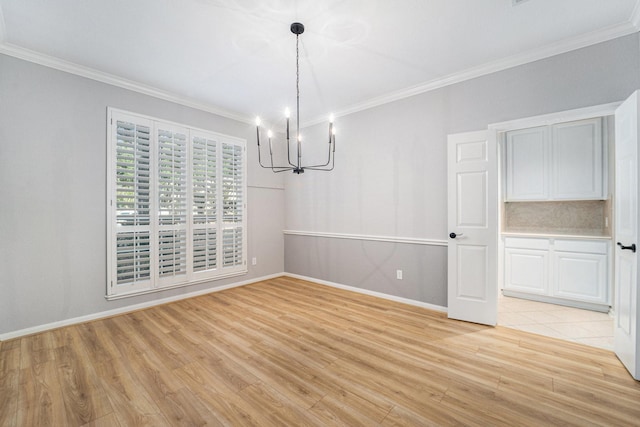 unfurnished dining area with a chandelier, light wood-type flooring, and ornamental molding