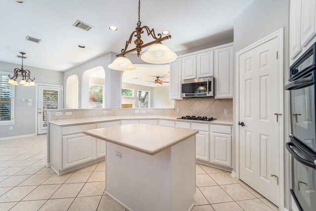 kitchen featuring white cabinetry, a kitchen island, stainless steel appliances, and light tile patterned floors