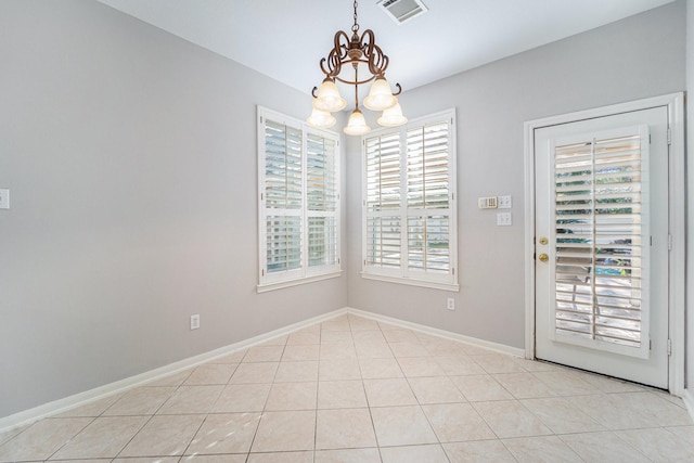 unfurnished dining area with an inviting chandelier, plenty of natural light, and light tile patterned flooring