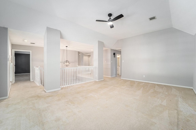 unfurnished living room featuring ceiling fan, light colored carpet, and vaulted ceiling