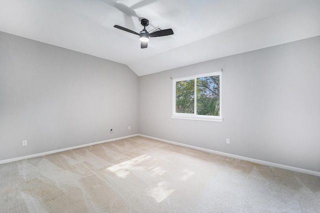 empty room featuring ceiling fan, light colored carpet, and lofted ceiling