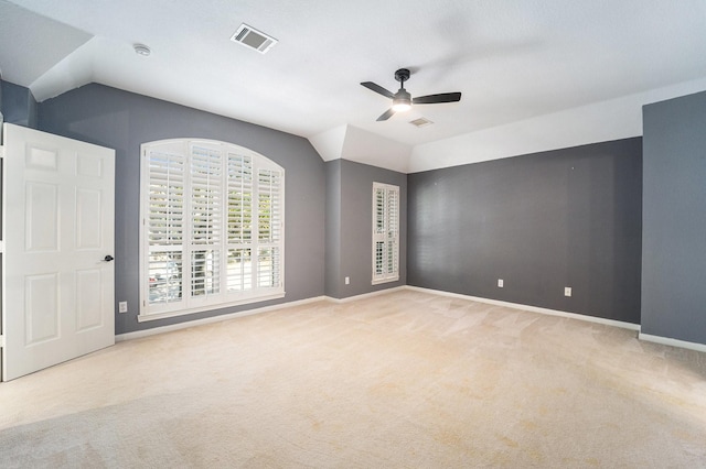 carpeted spare room with vaulted ceiling and ceiling fan