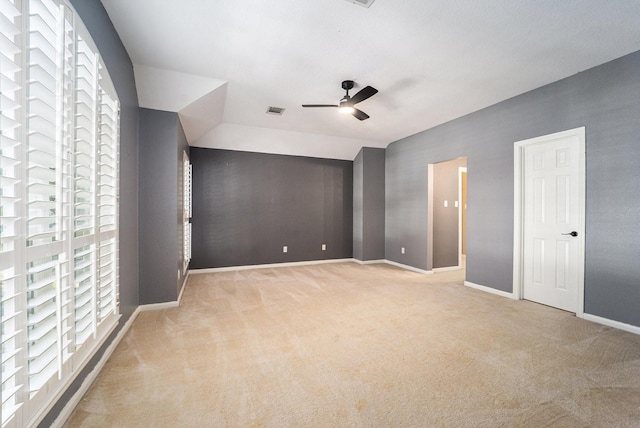 unfurnished bedroom featuring ceiling fan, light colored carpet, and vaulted ceiling