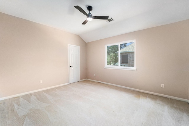 carpeted empty room featuring vaulted ceiling and ceiling fan