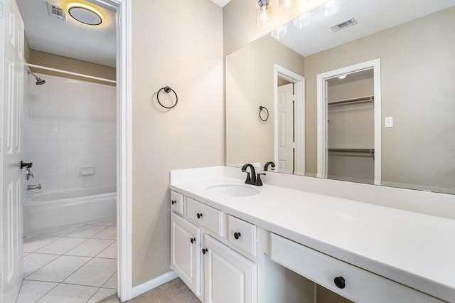 bathroom featuring tile patterned flooring, vanity, and tiled shower / bath