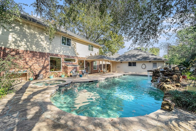 view of pool with a patio area, an in ground hot tub, and pool water feature