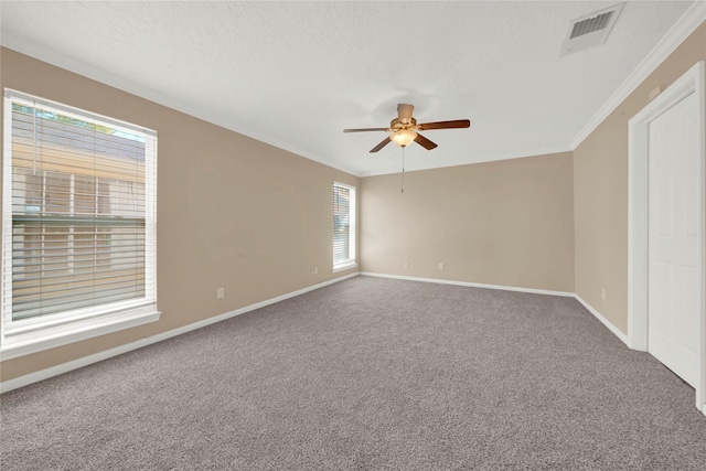 empty room featuring crown molding, carpet, and ceiling fan