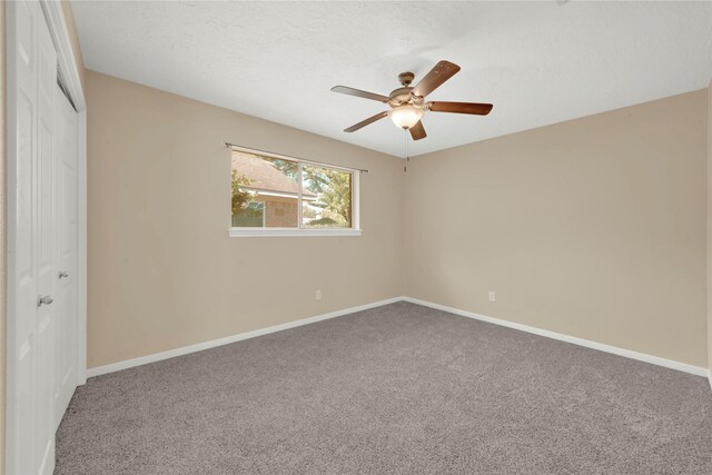 unfurnished bedroom featuring a textured ceiling, carpet floors, a closet, and ceiling fan