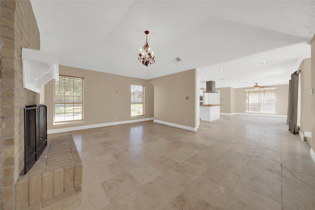 unfurnished living room with lofted ceiling and ceiling fan with notable chandelier