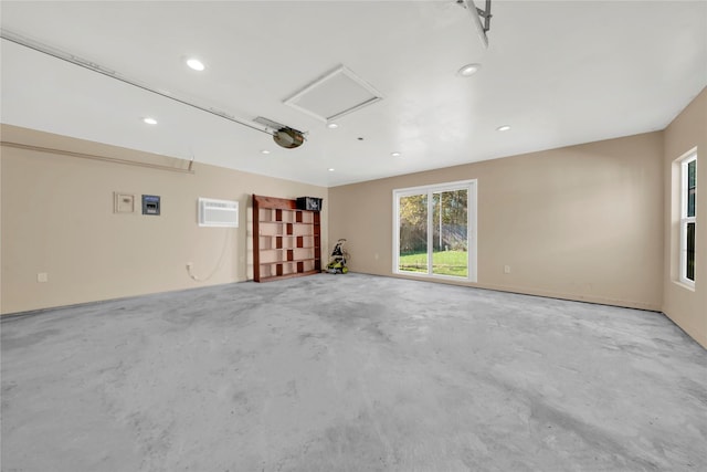 spare room with concrete flooring and an AC wall unit