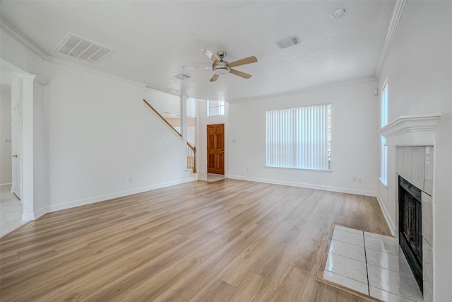 unfurnished living room featuring ceiling fan, light hardwood / wood-style floors, crown molding, and a tiled fireplace