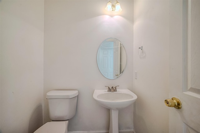 bathroom featuring toilet and a chandelier