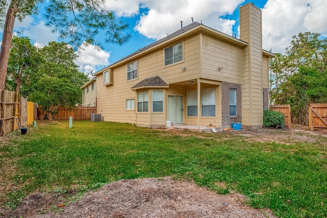 back of property with a yard and central AC unit