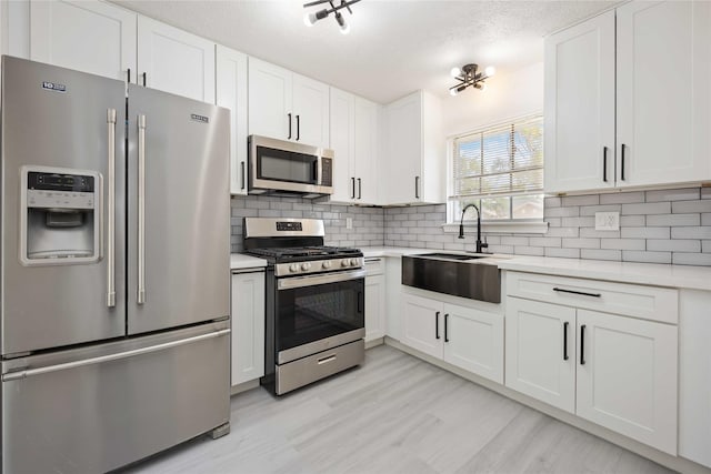 kitchen featuring decorative backsplash, white cabinets, and stainless steel appliances