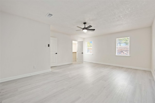 spare room with ceiling fan, light hardwood / wood-style flooring, and a textured ceiling