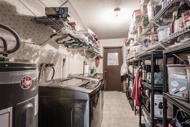 kitchen with electric water heater, washer and dryer, and a textured ceiling