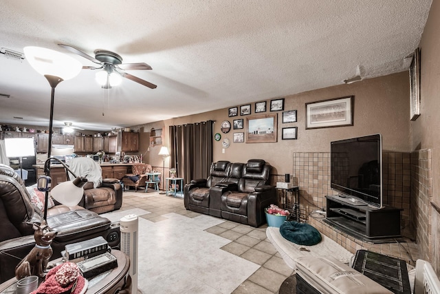 living room with ceiling fan and a textured ceiling