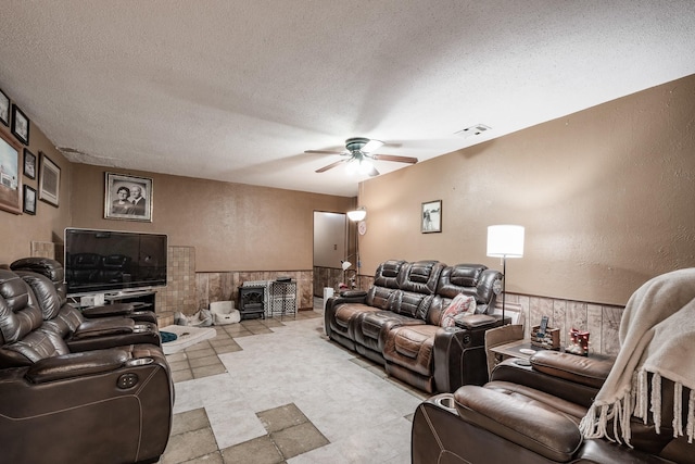 cinema featuring a textured ceiling, a wood stove, and ceiling fan