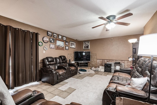 living room featuring ceiling fan and a textured ceiling