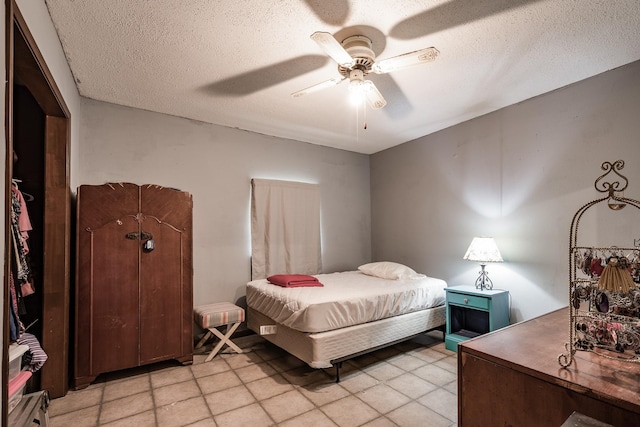 bedroom with ceiling fan and a textured ceiling