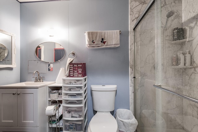 bathroom featuring vanity, toilet, and a shower with door