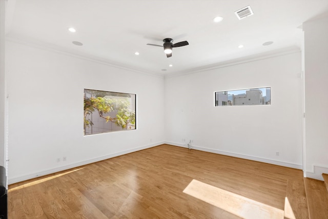 spare room with light wood-type flooring, ceiling fan, and crown molding