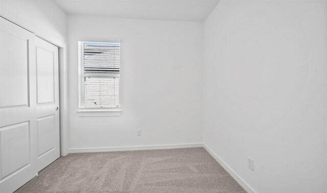 spare room featuring light colored carpet