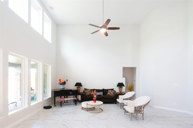 living room featuring ceiling fan and a high ceiling