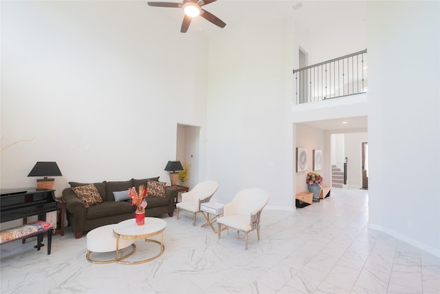 living room featuring ceiling fan and a high ceiling